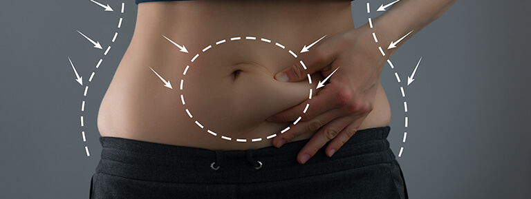 A woman with an untoned midriff pinches excess belly tissue between her fingers.